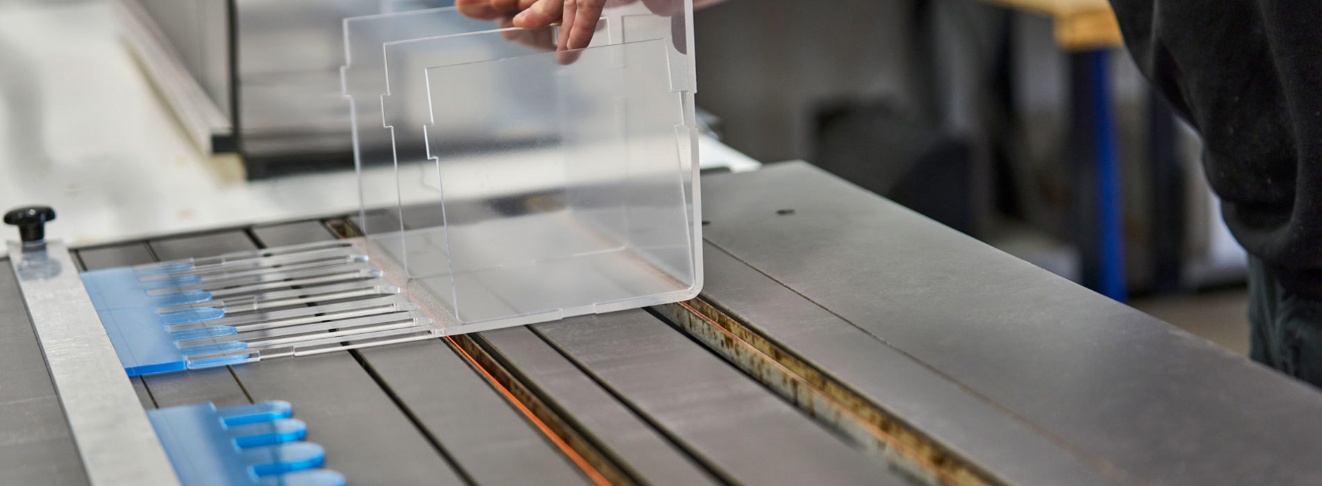 An employee adjusts a display of acrylic that lies on a heat-bending table.