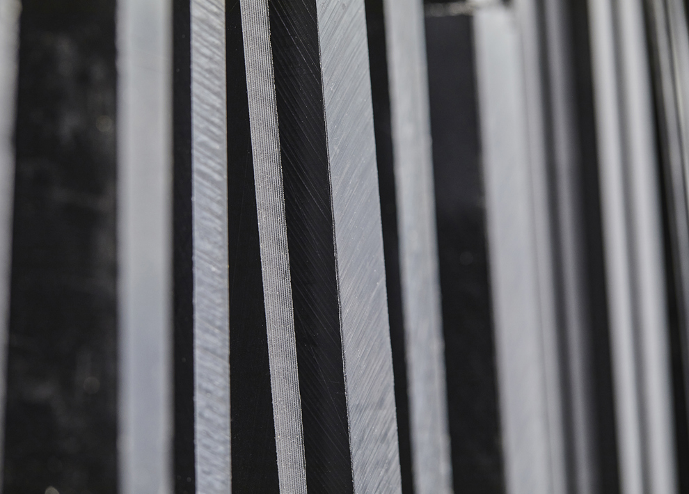 Sheets of black technical plastics on a shelf at Induflex's inventory in Støvring
